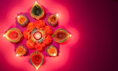 Mutlu Diwaliler - Dipavali sırasında Clay Diya lambaları yandı, Hindu ışık festivali kutlaması. Pembe arka planda renkli geleneksel gaz lambası diya