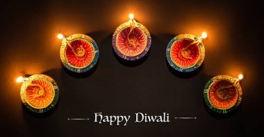 Mutlu Diwaliler - Dipavali sırasında Clay Diya lambaları yandı, Hindu ışık festivali kutlaması. Siyah arka planda renkli geleneksel gaz lambası diya