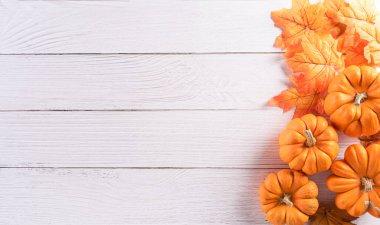 Kuru yapraklar ve ahşap arka plandaki balkabağından sonbahar dekorasyonu. Sonbahar, sonbahar, sonbahar, Şükran Günü konsepti için fotokopi alanı olan düz bir manzara..