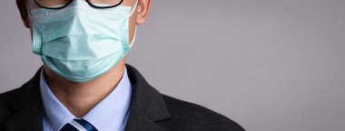 Koruyucu yüz maskesi takan bir iş adamının etrafını sarın. Coronavirus ve 2.5. Sağlık hizmetleri kavramı.