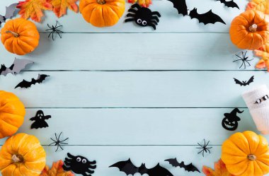 Cadılar Bayramı el sanatları, turuncu balkabağı, hayalet, yarasa ve örümceğin pastel ahşap arka planda fotokopi için yeri var. Cadılar Bayramı konsepti.