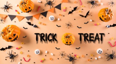 Cadılar Bayramı el sanatları, turuncu balkabağı, hayalet, yarasa ve turuncu arka planda siyah örümcek. Düz konum, üst görünüm Trick veya Treat metin ile.