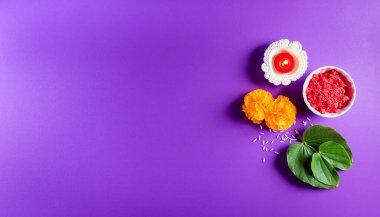 Mutlu Dussehra. Sarı çiçekler, yeşil yaprak ve mor pastel arka planda pirinç. Dussehra Hint Festivali konsepti.