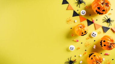 Cadılar Bayramı el sanatları, turuncu balkabağı, hayalet, yarasa ve sarı arka planda siyah örümcek. Düz konum, kopyalama alanı olan üst görünüm