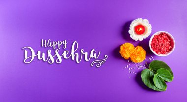 Mutlu Dussehra. Sarı çiçekler, yeşil yaprak ve mor pastel arka planda pirinç. Dussehra Hint Festivali konsepti.