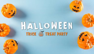 Pastel mavi arka planda turuncu hayalet balkabağından yapılmış Cadılar Bayramı el sanatları. Düz yatış, Cadılar Bayramı metniyle üstten görünüm.