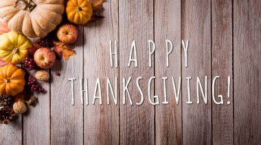 Şükran Günü ve Sonbahar kompozisyonu. Balkabağı, elma, kırmızı böğürtlen ve sonbahar yaprakları koyu ahşap arka planda.