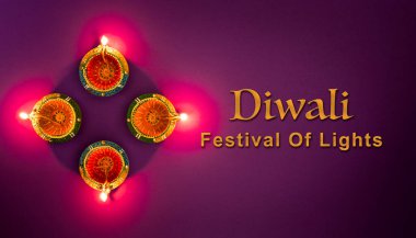 Mutlu Diwaliler - Dipavali sırasında Clay Diya lambaları yandı, Hindu ışık festivali kutlaması. Mor arka planda renkli geleneksel gaz lambası diya