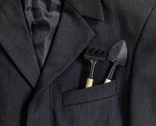 Ανδρικό σκούρο σακάκι σε μικρές λωρίδες κολάρο μανίκι τσέπη με το φτυάρι τσέπη και γκανιότα μαύρο στην ξύλινη λαβή — Φωτογραφία Αρχείου