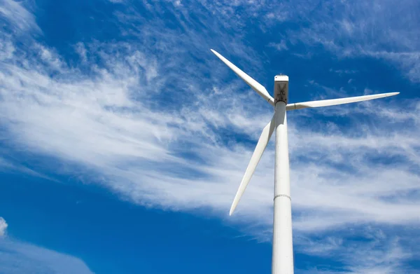 Generador eólico de electricidad a partir de tres palas sobre el fondo de nubes y cielo azul —  Fotos de Stock