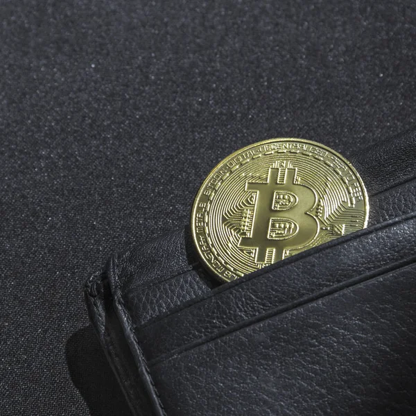 bir bokeh payetler ile siyah bir zemin üzerine siyah deri cüzdan çanta kripto para birimi para birimi bitcoin bir para ile para içindir