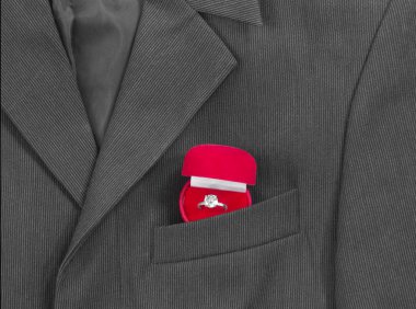 bir koyu siyah adamın ceketinin bir ışık şerit göğüs cebinde düğün yüzüğü için kırmızı bir kutu olduğunu