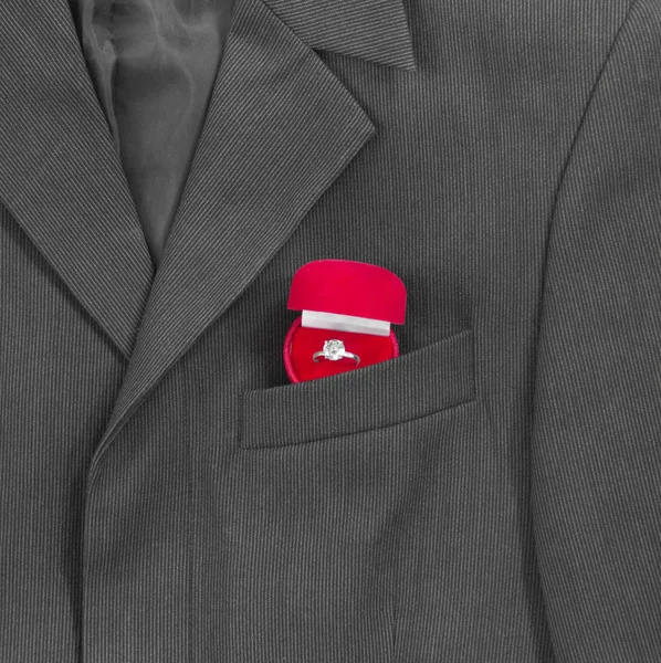 En el bolsillo del pecho de la chaqueta de un hombre negro oscuro en una tira de luz es una caja roja para el anillo de la boda —  Fotos de Stock