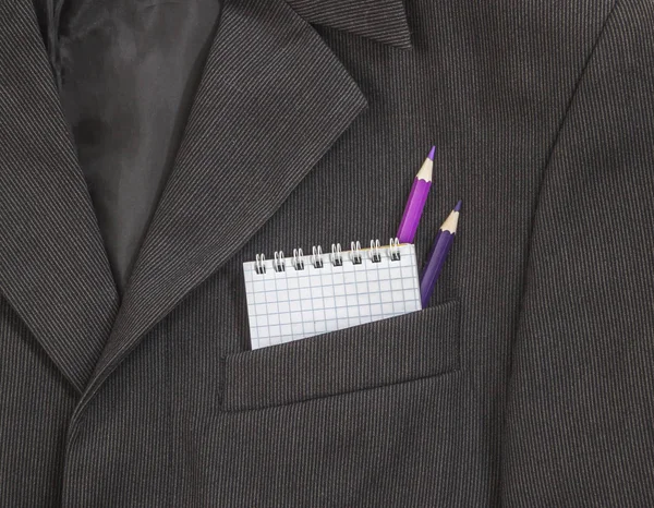 bir koyu siyah adamın göğüs cebinde kalem defter ve mor ve lila rengi parlak bir şerit üzerinde yaylar kafeste ceket