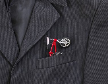 bir koyu siyah adamın ceketinin bir ışık şerit bir göğüs cebinde işte kırmızı çerçeve ile bir bisiklet