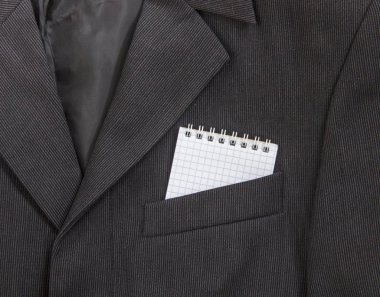 bir defter bir koyu siyah adamın ceketinin bir ışık şerit bir göğüs cebinde bir kafese yaylar üzerinde yatıyordu