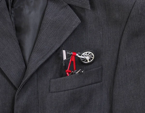 bir koyu siyah adamın ceketinin bir ışık şerit bir göğüs cebinde işte kırmızı çerçeve ile bir bisiklet