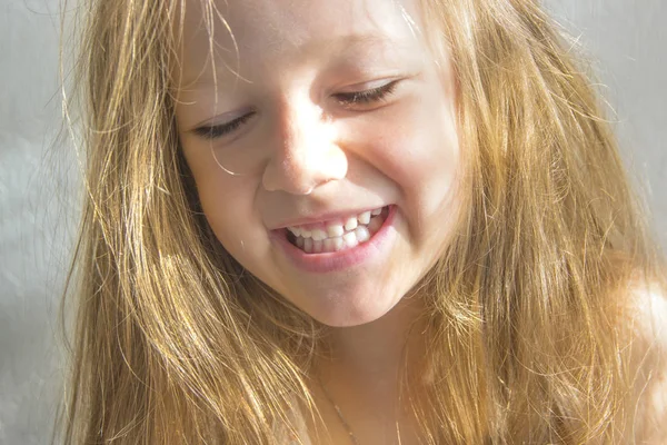 На білому тлі красива темноволоса брюнетка дівчина з розпущеним довгим волоссям, що посміхається тонування жовтого освітлення променів сонця світанку світанку інстаграм копіювати простір — стокове фото