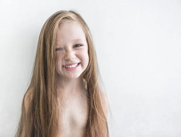 On white background beautiful dark-haired brunette girl with disheveled long hair smiling tinting yellow illumination rays of sun sunset dawn morning instagrams copyspace — Stock Photo, Image