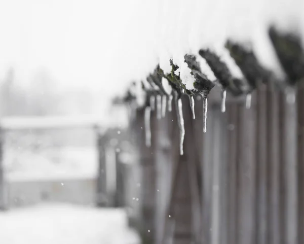Zawiesić się sople i śnieg pada na dach drewniany dom — Zdjęcie stockowe
