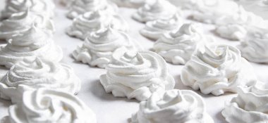 Beyaz pastel bir arka planda taze beyaz bir el yapımı marşmelov uzanıyor. Boşluğu kopyala