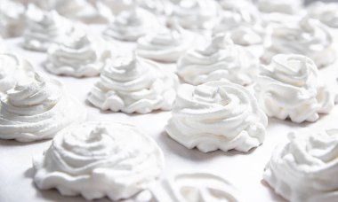 Beyaz pastel bir arka planda taze beyaz bir el yapımı marşmelov uzanıyor. Boşluğu kopyala 