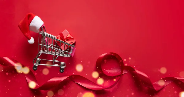 Auf Rotem Hintergrund Liegt Ein Einkaufswagen Auf Rädern Mit Einem — Stockfoto