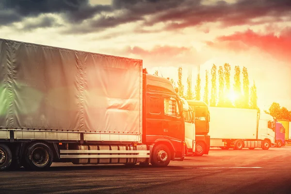 Conceito logístico e de transporte, caminhões de contêineres para entrega de carga ao pôr do sol — Fotografia de Stock