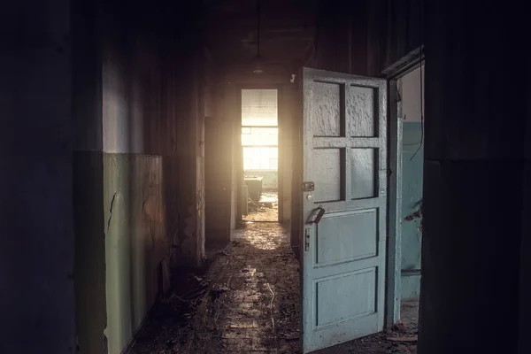 Couloir sombre vide sale dans un bâtiment abandonné, portes, lumière à la fin, perspective, chemin vers la liberté — Photo