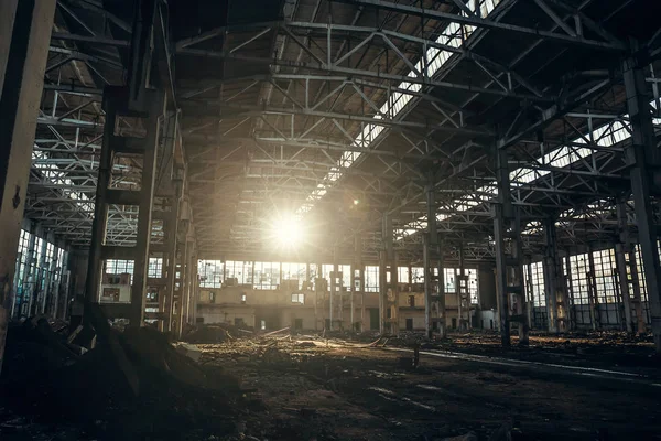 Покинутий промисловий моторошний склад всередині старої темної гранжевої заводської будівлі на сонячному світлі — стокове фото