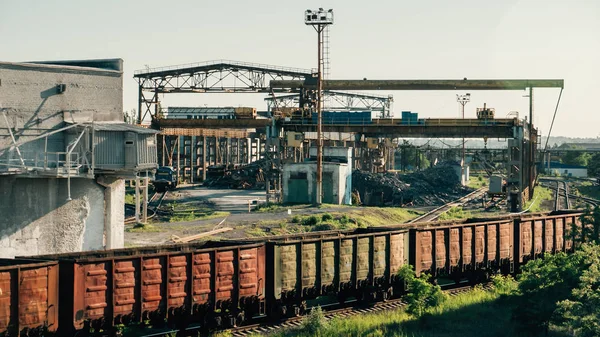 Вантажні вагони йдуть залізницею в промисловій зоні з заводами і виробничими заводами — стокове фото