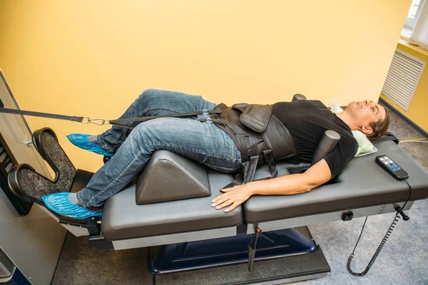 Male patient at non-surgical treatment physiotherapy of lumbar spine and spinal cord dilatation in medical center — Stock Image Male patient at non-surgical treatment physiotherapy of lumbar spine and spinal cord dilatation in medical center Stock Photo