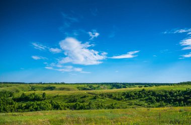 Yeşil doğa manzara otlak tepeler ve mavi gökyüzü, sakin kırsal ile