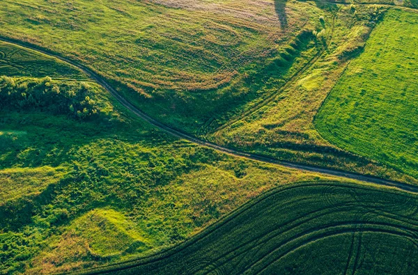 Vista aérea desde el avión no tripulado o aerostato en las tierras rurales rurales rurales con colinas y prados de campo verde, paisaje de vista superior — Foto de Stock