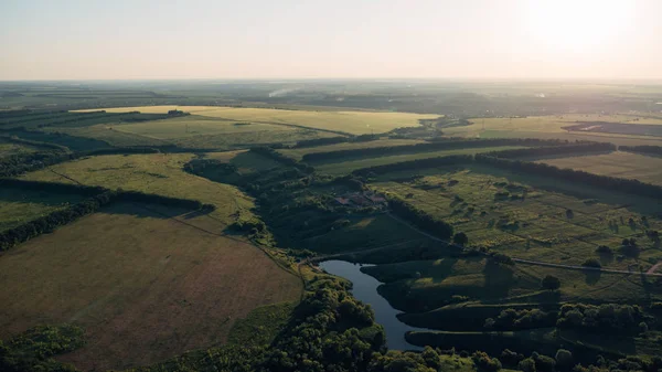 Vista superior, foto aérea do drone ou aerostat ao panorama da paisagem da natureza do verão, prados verdes e rio no campo na hora do pôr do sol — Fotografia de Stock