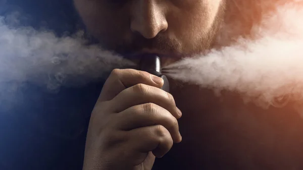 Ember vape e-cigaretta, e-folyadék, közelkép, lélegzik nagy felhő, gőz vagy pára. Vaping concept, fény hatása — Stock Fotó