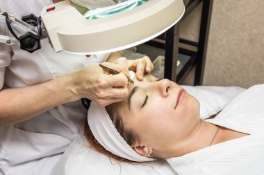 Şevval özçelik güzellik plucks kaşları ekipmanlı, klinikte genç kız hastadan kapatın. Kozmetik, yüz ve kadınsı güzellik