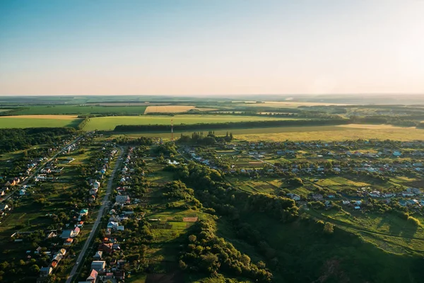 Vista aérea do drone ou aerostat ao panorama da paisagem da natureza do verão, prados verdes, estradas, casas no campo na hora do por do sol, fundo da viagem — Fotografia de Stock