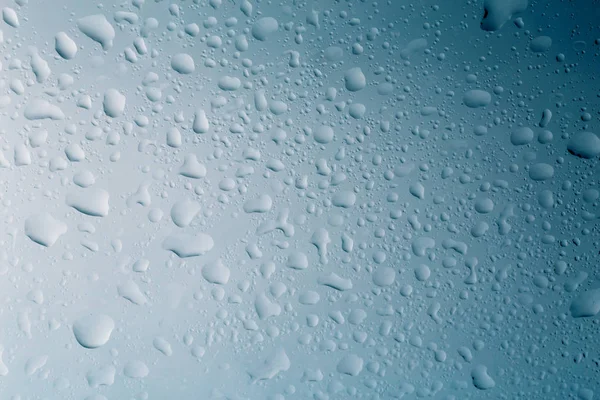 Gouttelettes d'eau sur verre ou fenêtre avec fond bleu, gouttes de surface liquide, macro — Photo