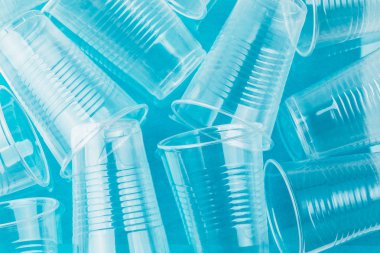 Yeni temiz boş şeffaf tek kullanımlık plastik gözlük mavi arka plan, üstten görünüm