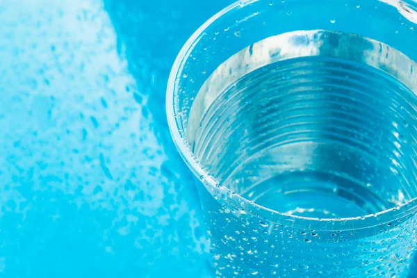 일회용 플라스틱 유리 또는 밝은 파란색 배경, 복사 공간에 신선한 맑은 물 컵 — 스톡 사진