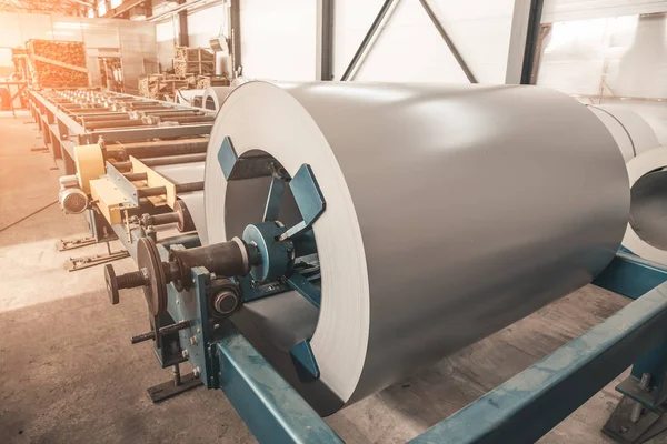 Bobina de rollo de acero galvanizado industrial para máquina formadora de chapas metálicas en taller de fábrica de metalurgia, luz solar — Foto de Stock