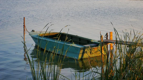 Старая деревянная лодка на озере вечером — стоковое фото
