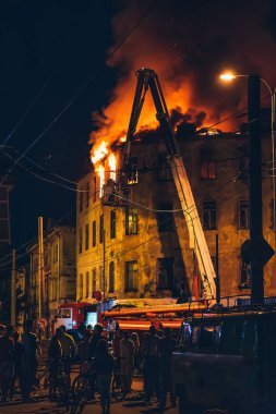 Apartman, alev ile itfaiye mücadele gece yangın siluetleri tanınmaz halde insanların etrafında durmak. Yangın felaketi ve kaza trajedi kavramı