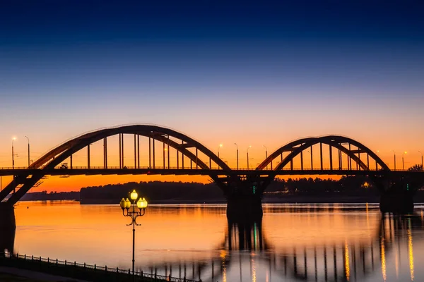 Pont de la Volga sur la Volga après le coucher du soleil avec réflexion dans l'eau, région de Yaroslavl, ville de Rybinsk, Russie. Beau paysage nocturne — Photo