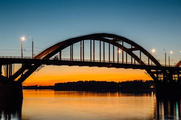 Wolga-Brücke über die Wolga nach Sonnenuntergang mit Reflexion im Wasser, Gebiet Jaroslawl, Stadt Rybinsk, Russland. schöne Abendlandschaft — Stockfoto