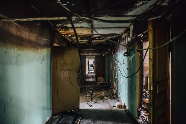 Sucio pasillo oscuro vacío en edificio abandonado, puertas rotas, basura, perspectiva — Foto de Stock