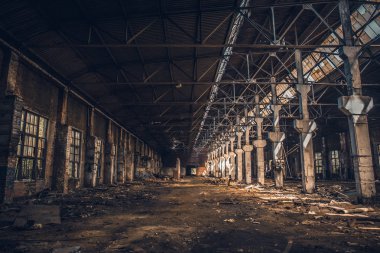 Harap ve terk edilmiş karanlık endüstriyel ürpertici ambarla içinde sütunlar, koridor veya tünel görünümünde, eski grunge fabrika binası