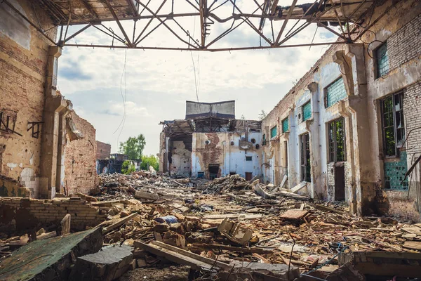 Edifício industrial abandonado arruinado com grandes pílulas de lixo de concreto, após desastre natural, furacão, terremoto ou guerra — Fotografia de Stock