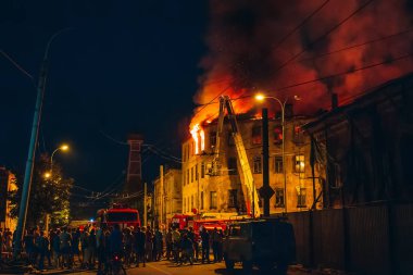 Gece yangın binanın, alev ile itfaiye mücadele içinde insanlar etrafında durmak. Yangın felaketi ve kaza trajedi